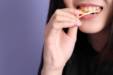 Mor arka planda portakal meyvesi tutan Asyalı kadın..