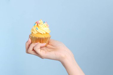 Mavi arka planda kek yiyen Asyalı kadın..