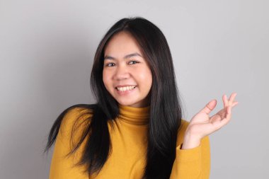 Gri arka planda duran Güneydoğu Asya 'lı yetişkin kadın..