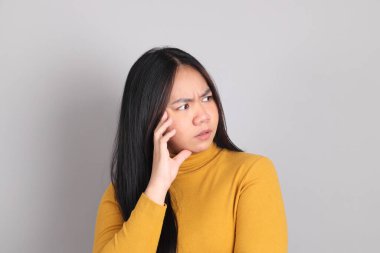 Gri arka planda duran Güneydoğu Asya 'lı yetişkin kadın..