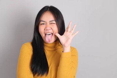 Gri arka planda duran Güneydoğu Asya 'lı yetişkin kadın..