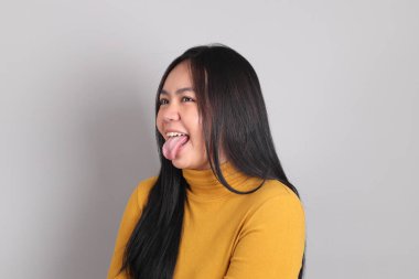 Gri arka planda duran Güneydoğu Asya 'lı yetişkin kadın..