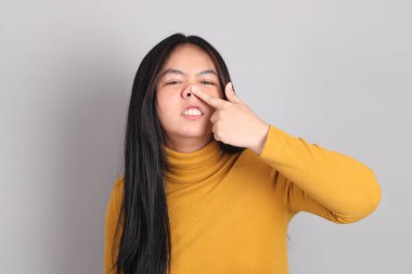 Gri arka planda duran Güneydoğu Asya 'lı yetişkin kadın..