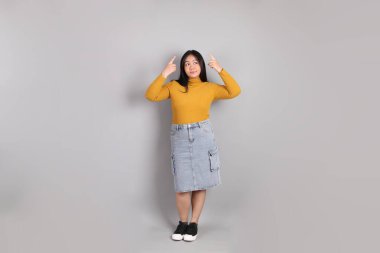 Gri arka planda duran Güneydoğu Asya 'lı yetişkin kadın..