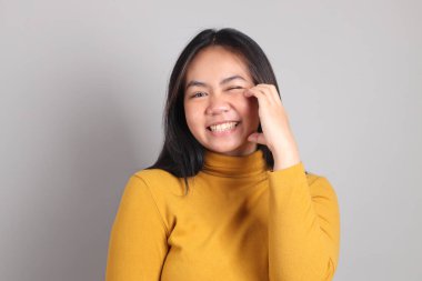 Gri el işaretinin üzerinde duran Güneydoğu Asya 'lı yetişkin kadın..