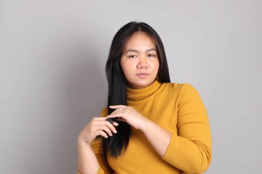 Gri el işaretinin üzerinde duran Güneydoğu Asya 'lı yetişkin kadın..