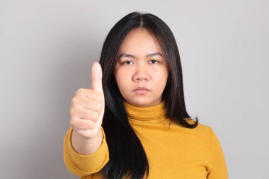 Gri el işaretinin üzerinde duran Güneydoğu Asya 'lı yetişkin kadın..