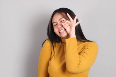 Gri el işaretinin üzerinde duran Güneydoğu Asya 'lı yetişkin kadın..