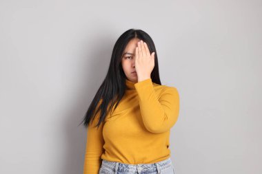 Gri el işaretinin üzerinde duran Güneydoğu Asya 'lı yetişkin kadın..