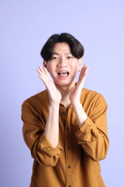 Mavi arka planda diş telleri olan Doğu Asyalı yetişkin adam..