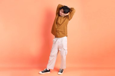 Pembe ya da turuncu arka planda diş telleri olan Doğu Asyalı yetişkin adam..