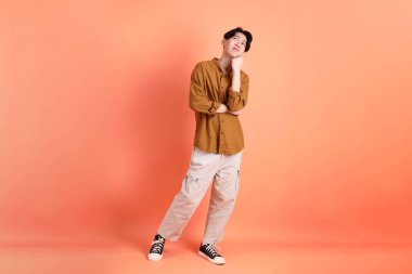 Pembe ya da turuncu arka planda diş telleri olan Doğu Asyalı yetişkin adam..