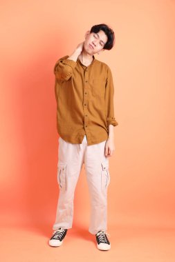 Pembe ya da turuncu arka planda diş telleri olan Doğu Asyalı yetişkin adam..