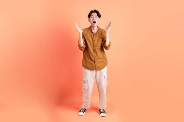 Pembe ya da turuncu arka planda diş telleri olan Doğu Asyalı yetişkin adam..