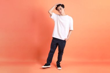 Pembe ya da turuncu arka planda diş telleri olan Doğu Asyalı yetişkin adam..