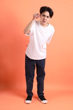 Pembe ya da turuncu arka planda diş telleri olan Doğu Asyalı yetişkin adam..