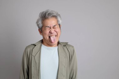 Gri arka planda duran 40 'lı yılların Asyalı, şık, sıradan elbiseli adamı.. 