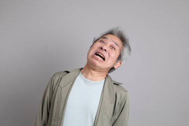 Gri arka planda duran 40 'lı yılların Asyalı, şık, sıradan elbiseli adamı.. 