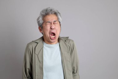 Gri arka planda duran 40 'lı yılların Asyalı, şık, sıradan elbiseli adamı.. 