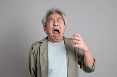 Gri arka planda duran 40 'lı yılların Asyalı, şık, sıradan elbiseli adamı.. 