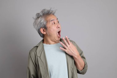 Gri arka planda duran 40 'lı yılların Asyalı, şık, sıradan elbiseli adamı.. 