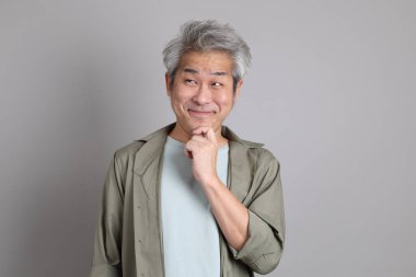 Gri arka planda duran 40 'lı yılların Asyalı, şık, sıradan elbiseli adamı.. 