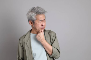 Gri arka planda duran 40 'lı yılların Asyalı, şık, sıradan elbiseli adamı.. 