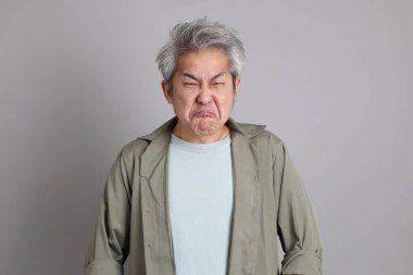 Gri arka planda duran 40 'lı yılların Asyalı, şık, sıradan elbiseli adamı.. 