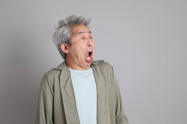 Gri arka planda duran 40 'lı yılların Asyalı, şık, sıradan elbiseli adamı.. 