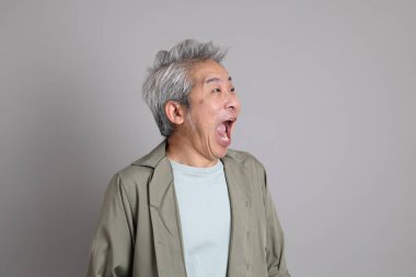 Gri arka planda duran 40 'lı yılların Asyalı, şık, sıradan elbiseli adamı.. 