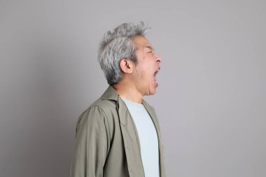 Gri arka planda duran 40 'lı yılların Asyalı, şık, sıradan elbiseli adamı.. 