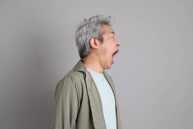 Gri arka planda duran 40 'lı yılların Asyalı, şık, sıradan elbiseli adamı.. 