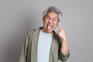 Gri arka planda duran 40 'lı yılların Asyalı, şık, sıradan elbiseli adamı.. 