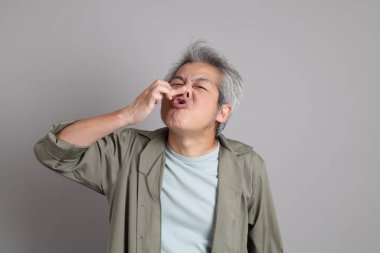 Gri arka planda duran 40 'lı yılların Asyalı, şık, sıradan elbiseli adamı.. 