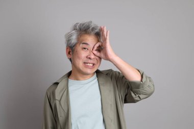 Gri arka planda duran 40 'lı yılların Asyalı, şık, sıradan elbiseli adamı.. 