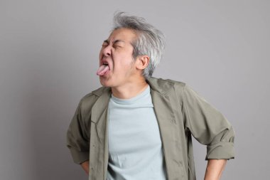 Gri arka planda duran 40 'lı yılların Asyalı, şık, sıradan elbiseli adamı.. 