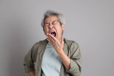 Gri arka planda duran 40 'lı yılların Asyalı, şık, sıradan elbiseli adamı.. 