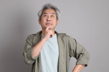 Gri arka planda duran 40 'lı yılların Asyalı, şık, sıradan elbiseli adamı.. 