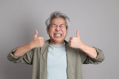 Gri arka planda duran 40 'lı yılların Asyalı, şık, sıradan elbiseli adamı.. 