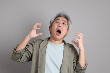 Gri arka planda duran 40 'lı yılların Asyalı, şık, sıradan elbiseli adamı.. 