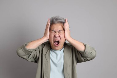 Gri arka planda duran 40 'lı yılların Asyalı, şık, sıradan elbiseli adamı.. 