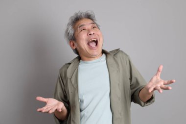 Gri arka planda duran 40 'lı yılların Asyalı, şık, sıradan elbiseli adamı.. 