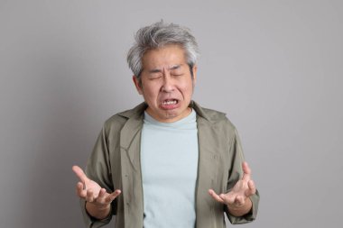 Gri arka planda duran 40 'lı yılların Asyalı, şık, sıradan elbiseli adamı.. 