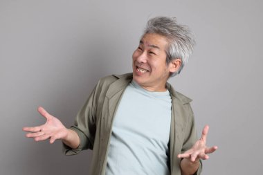 Gri arka planda duran 40 'lı yılların Asyalı, şık, sıradan elbiseli adamı.. 