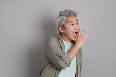 Gri arka planda duran 40 'lı yılların Asyalı, şık, sıradan elbiseli adamı.. 