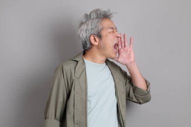 Gri arka planda duran 40 'lı yılların Asyalı, şık, sıradan elbiseli adamı.. 