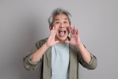 Gri arka planda duran 40 'lı yılların Asyalı, şık, sıradan elbiseli adamı.. 