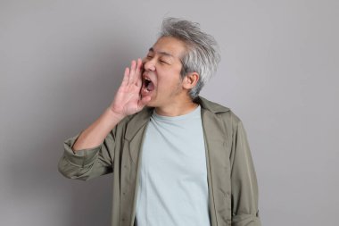 Gri arka planda duran 40 'lı yılların Asyalı, şık, sıradan elbiseli adamı.. 