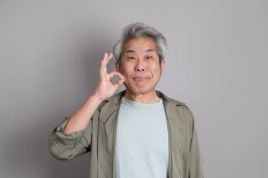 Gri arka planda duran 40 'lı yılların Asyalı, şık, sıradan elbiseli adamı.. 