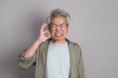 Gri arka planda duran 40 'lı yılların Asyalı, şık, sıradan elbiseli adamı.. 